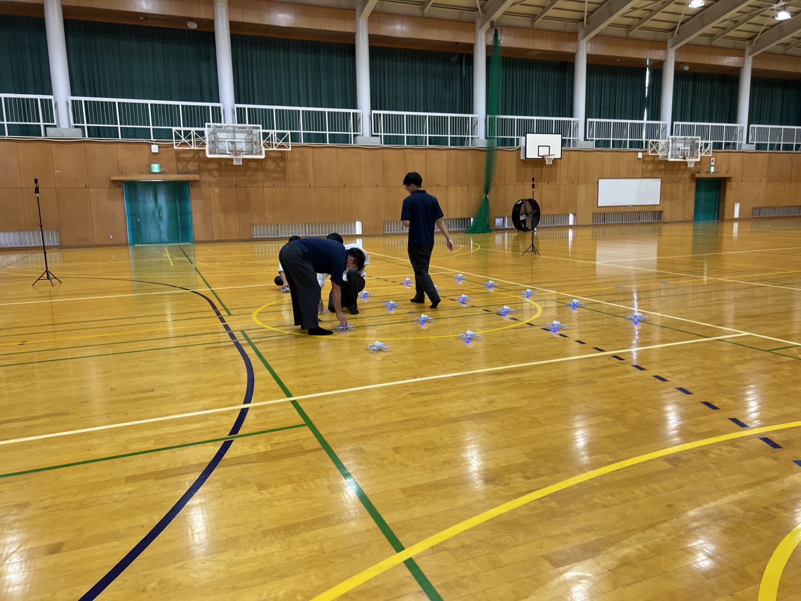 体育館で生徒がドローンを配置する授業風景